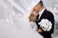 groom-in-black-tuxedo-hugs-tender-stunning-bride-while-they-stand (1)